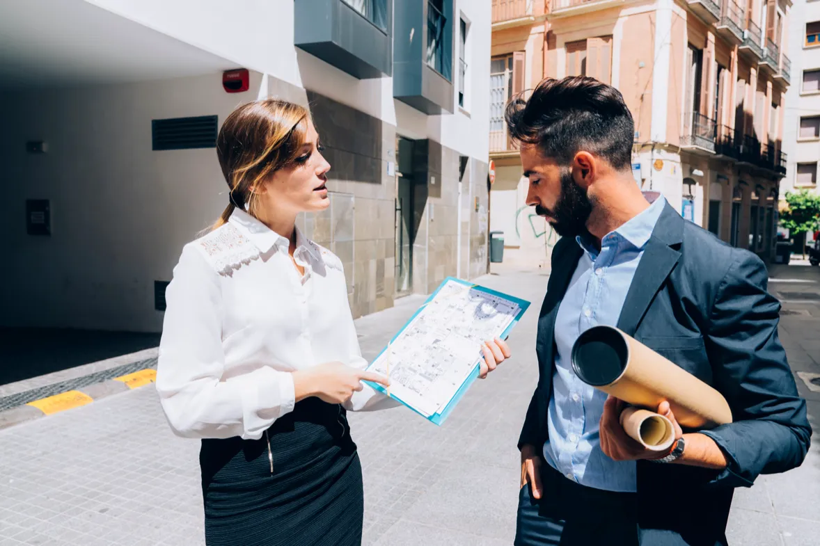 Une commerciale NEOSENIA présente un plan à un commerçant dans la rue